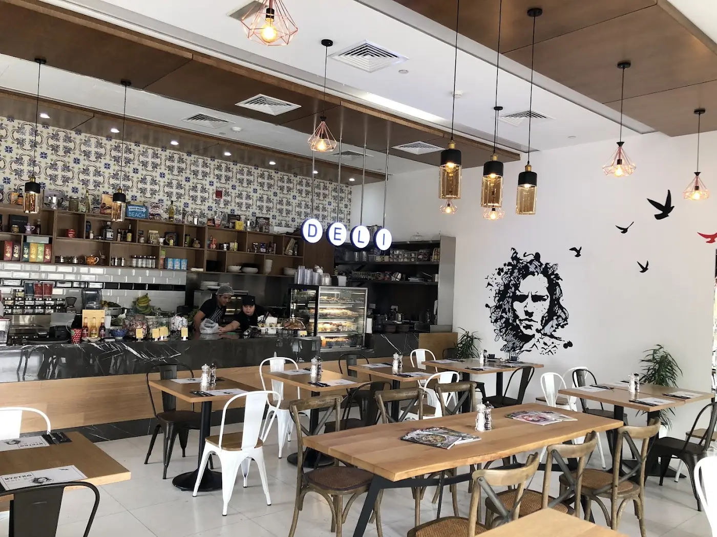 Inside Autograph Deli: wooden shelves, framed portrait and seating